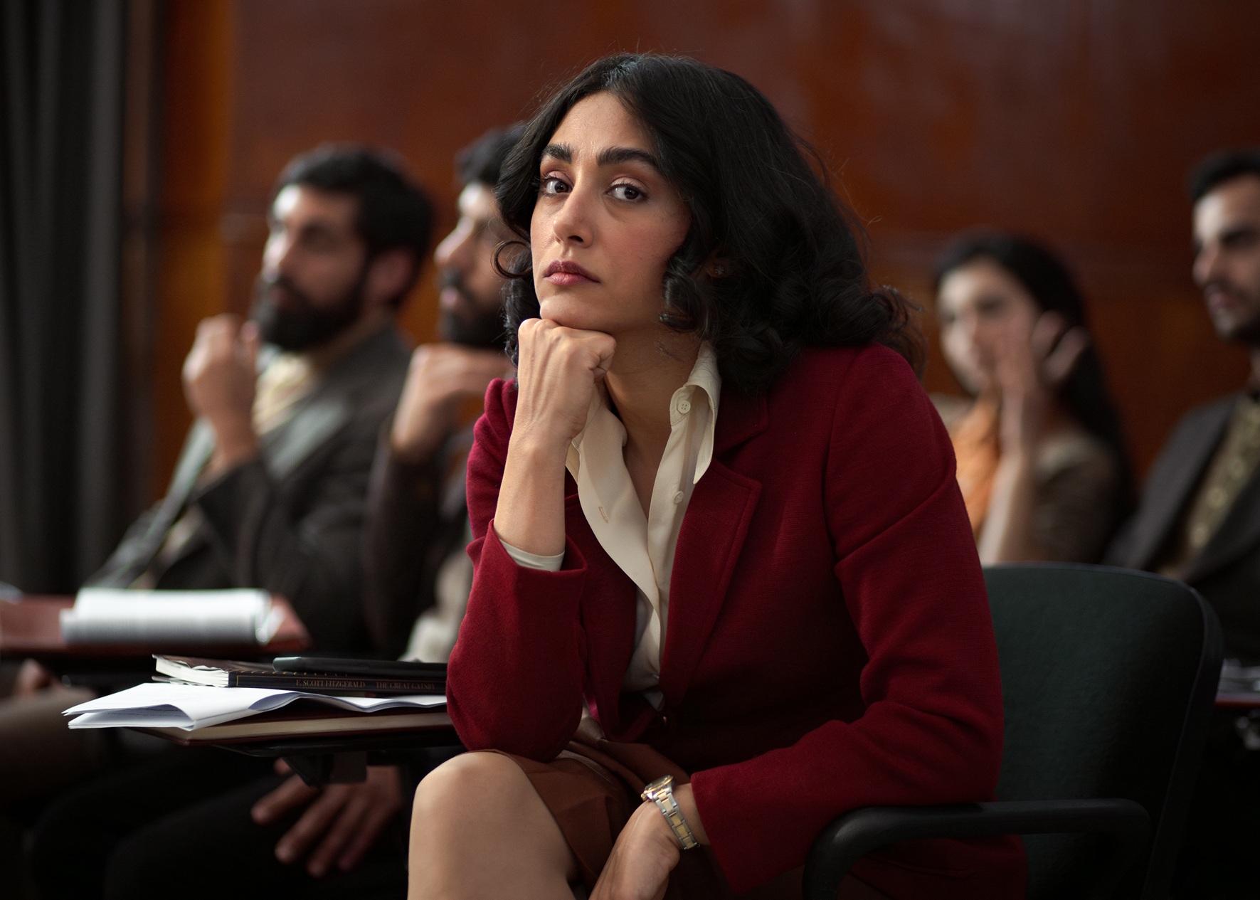 Sitzende Frau stützt nachdenklich ihr Gesicht auf den Arm, blickt den Betrachtenden an. Filmstill aus Lolita lesen in Teheran